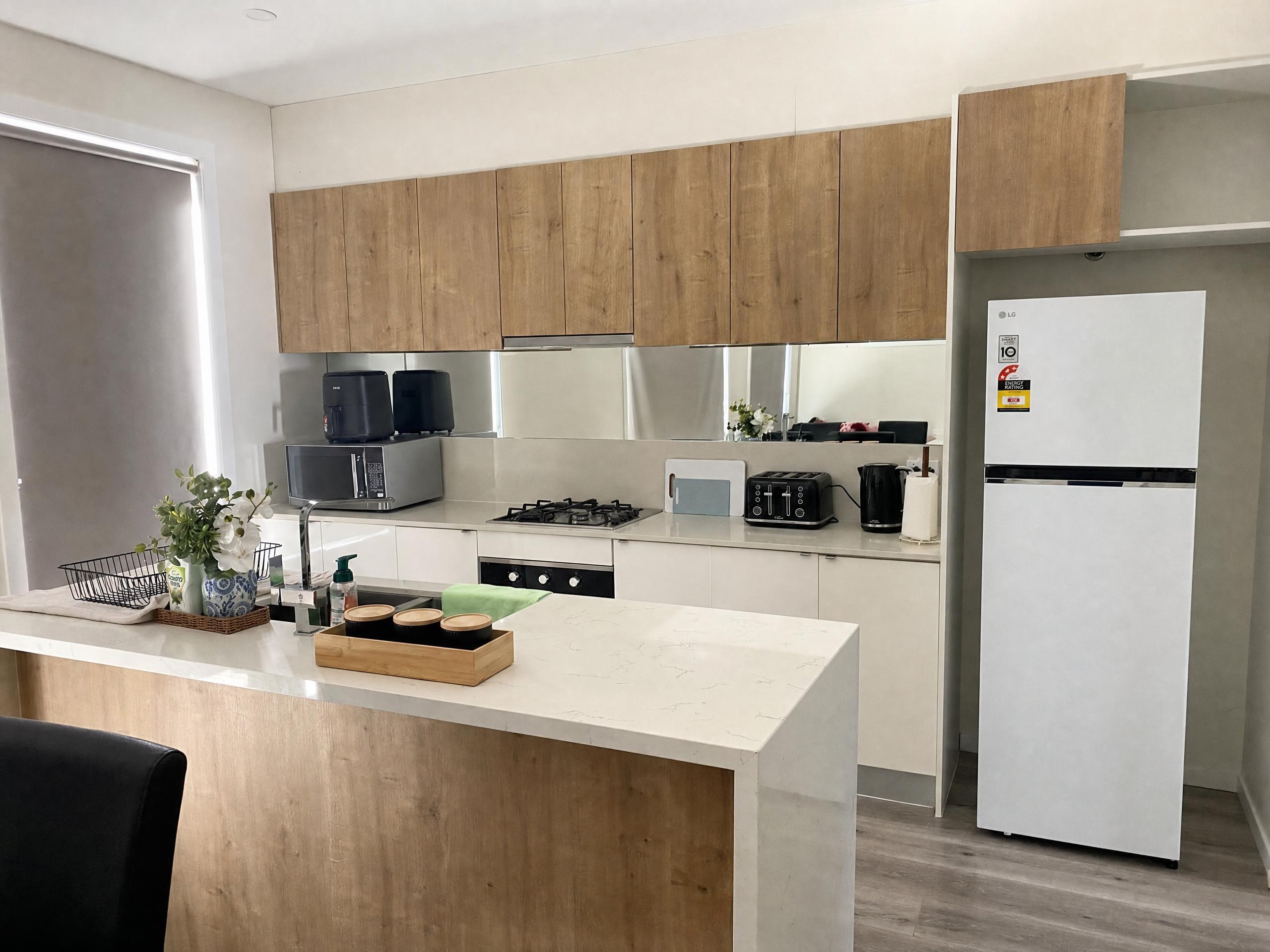 Full kitchen with island, oven and fridge at Luxe Nest, 33 Maya Avenue