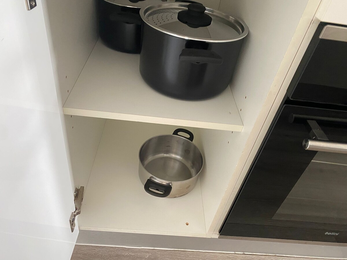 Kitchen cupboard with pots and pans at Luxe Nest, 33 Maya Avenue