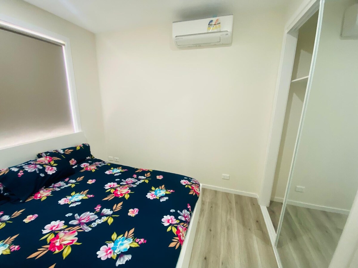 Bedroom with navy floral quilt at Luxe Nest, 33 Maya Avenue