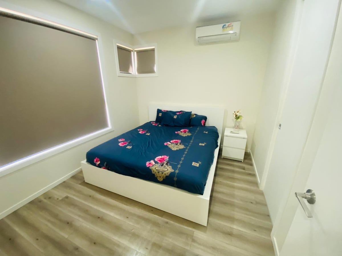 Bedroom with navy floral quilt and bedside tables at Luxe Nest, 33 Maya Avenue