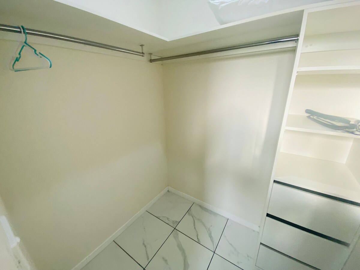Walk-in wardrobe with drawers and hanging rail at Luxe Nest, 33 Maya Avenue